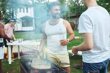 Image showing Group of friends making barbecue in the backyard. concept about good and positive mood with friends