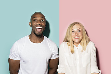 Image showing happy afro man and woman. Dynamic image of caucasian female and afro male model on pink studio.