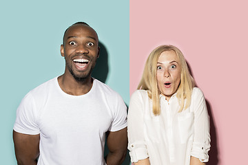 Image showing happy afro man and woman. Dynamic image of caucasian female and afro male model on pink studio.