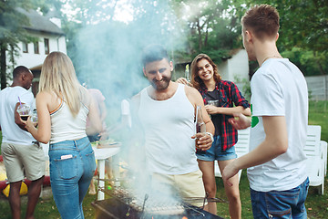 Image showing Group of friends making barbecue in the backyard. concept about good and positive mood with friends