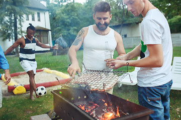 Image showing Group of friends making barbecue in the backyard. concept about good and positive mood with friends