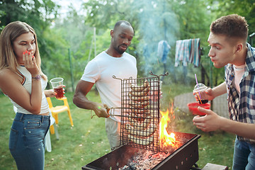 Image showing Group of friends making barbecue in the backyard. concept about good and positive mood with friends