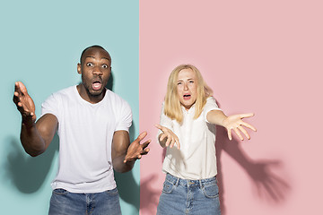 Image showing The afro surprised couple watching sports match on tv at home, successful game. Different emotions concept. Studio shot with african american man and woman