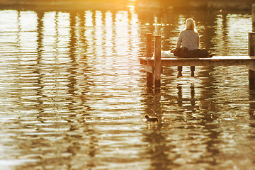 Image showing a woman sitting on a wooden jetty at Starnberg Lake Tutzing Bava