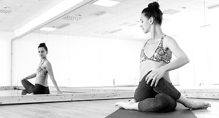 Image showing Fit sporty active girl in fashion sportswear doing yoga fitness exercise in in yoga studio.