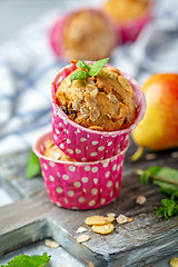 Image showing Freshly baked muffins with pear in paper forms.