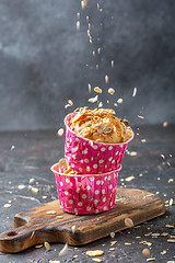 Image showing Muffins with pears and muesli in pink paper forms.