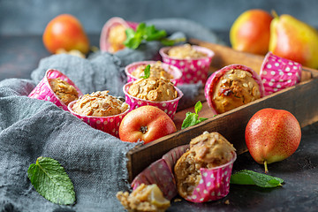 Image showing Muffins with pears and muesli in a wooden tray.