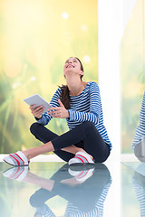 Image showing young women using tablet computer on the floor