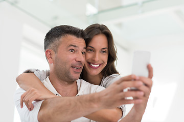 Image showing happy couple using mobile phone at home