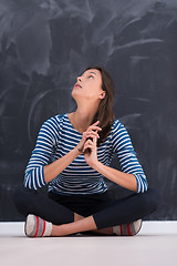 Image showing woman sitting in front of chalk drawing board