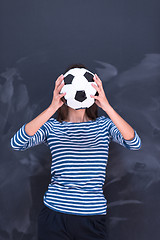 Image showing woman holding a soccer ball in front of chalk drawing board