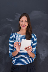 Image showing woman using tablet  in front of chalk drawing board