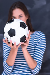 Image showing woman holding a soccer ball in front of chalk drawing board