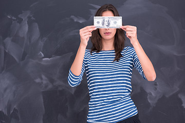 Image showing woman holding a banknote in front of chalk drawing board