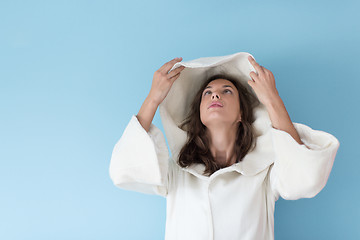 Image showing woman in a white coat with hood isolated on blue background