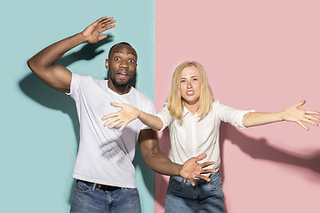 Image showing The afro surprised couple watching sports match on tv at home, successful game. Different emotions concept. Studio shot with african american man and woman