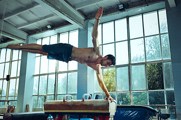 Image showing The sportsman during difficult exercise, sports gymnastics