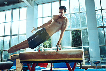 Image showing The sportsman during difficult exercise, sports gymnastics