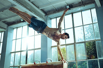 Image showing The sportsman during difficult exercise, sports gymnastics