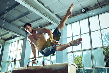 Image showing The sportsman during difficult exercise, sports gymnastics