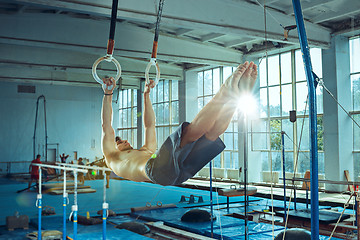 Image showing The sportsman during difficult exercise, sports gymnastics