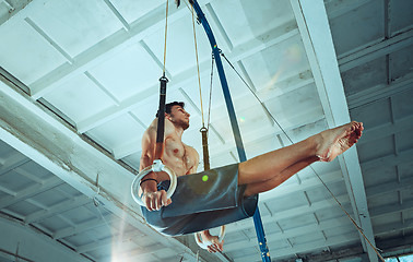 Image showing The sportsman during difficult exercise, sports gymnastics