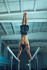 Image showing The sportsman during difficult exercise, sports gymnastics