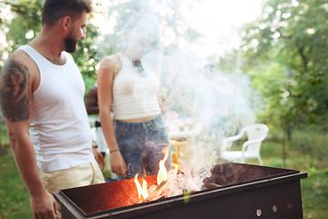 Image showing Group of friends making barbecue in the backyard. concept about good and positive mood with friends