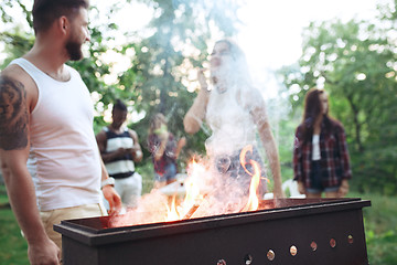 Image showing Group of friends making barbecue in the backyard. concept about good and positive mood with friends