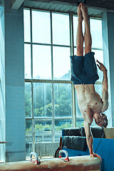 Image showing The sportsman during difficult exercise, sports gymnastics
