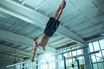 Image showing The sportsman during difficult exercise, sports gymnastics