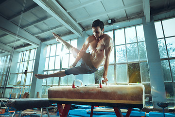 Image showing The sportsman during difficult exercise, sports gymnastics