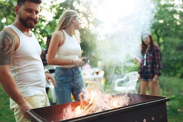 Image showing Group of friends making barbecue in the backyard. concept about good and positive mood with friends