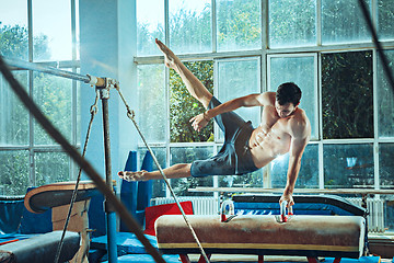 Image showing The sportsman during difficult exercise, sports gymnastics