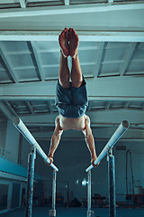 Image showing The sportsman during difficult exercise, sports gymnastics