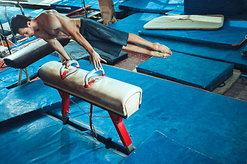 Image showing The sportsman during difficult exercise, sports gymnastics