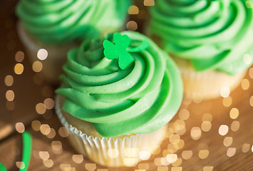 Image showing green cupcakes and shamrock on wooden table