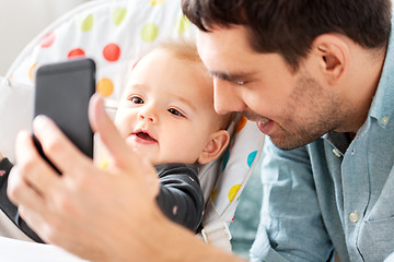 Image showing father with baby daughter taking selfie at home