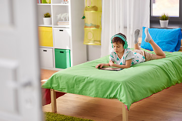 Image showing boy with tablet pc and headphones at home