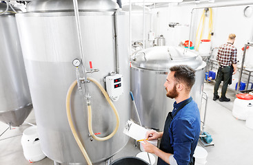 Image showing man with clipboard at craft brewery or beer plant