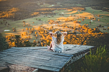 Image showing Woman watching the sunset over the mountain valley