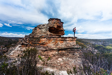 Image showing Female explorer standing on top of pagoda with cave and balcony