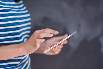 Image showing woman using tablet  in front of chalk drawing board