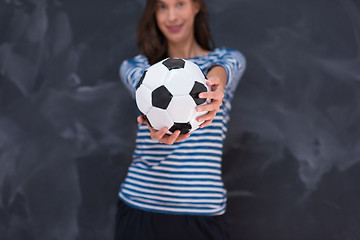 Image showing woman holding a soccer ball in front of chalk drawing board