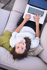 Image showing Young woman using laptop at home top view