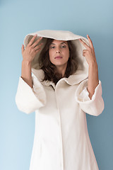 Image showing woman in a white coat with hood isolated on blue background