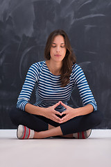 Image showing woman sitting in front of chalk drawing board