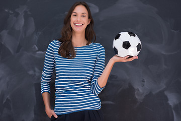 Image showing woman holding a soccer ball in front of chalk drawing board