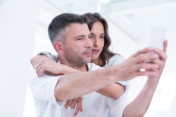 Image showing happy couple using mobile phone at home